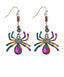 A pair of dangling spider earrings with iridescent rainbow-colored legs, silver hooks, and large pink teardrop gemstones on a plain white background.