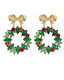 A pair of gold-tone dangle earrings designed as Christmas wreaths, featuring green marquise and round crystals for leaves and berries, with red crystal accents and bow-shaped posts at the top, shown on a plain white background.