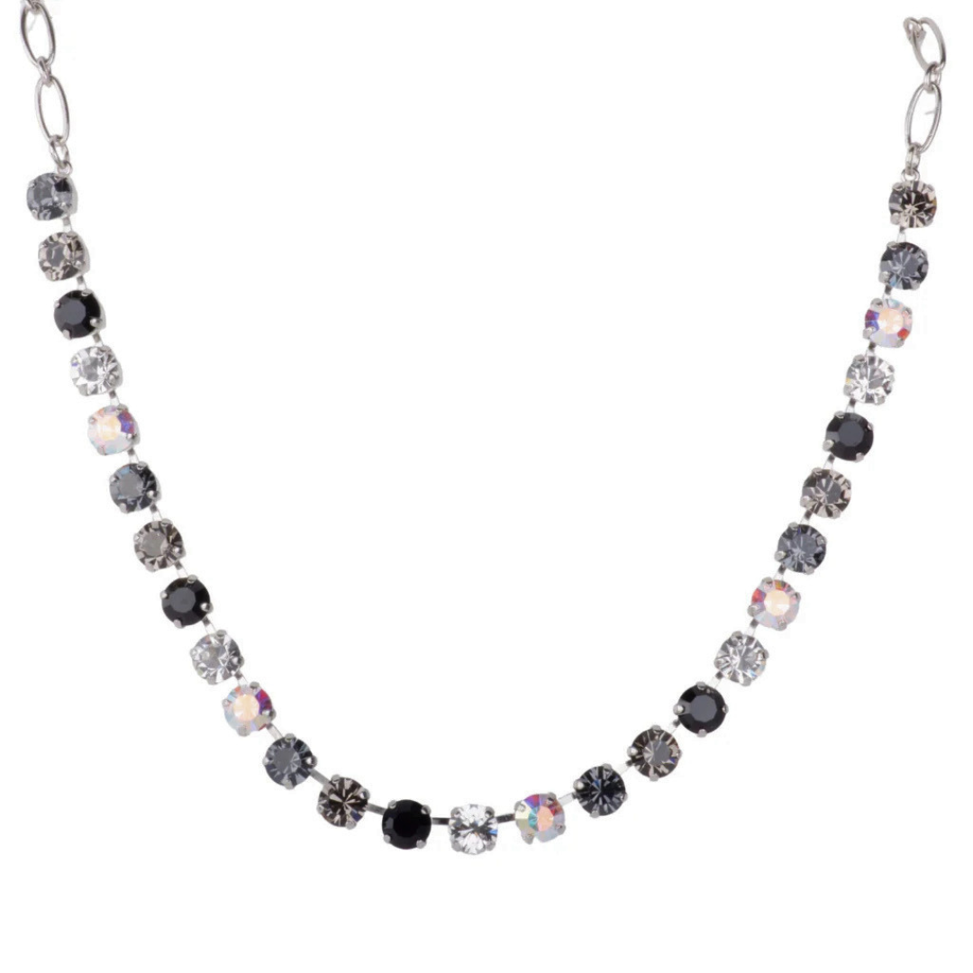 A silver-tone chain necklace featuring alternating round faceted gemstones in black, smoky gray, and iridescent white, displayed on a solid white background.