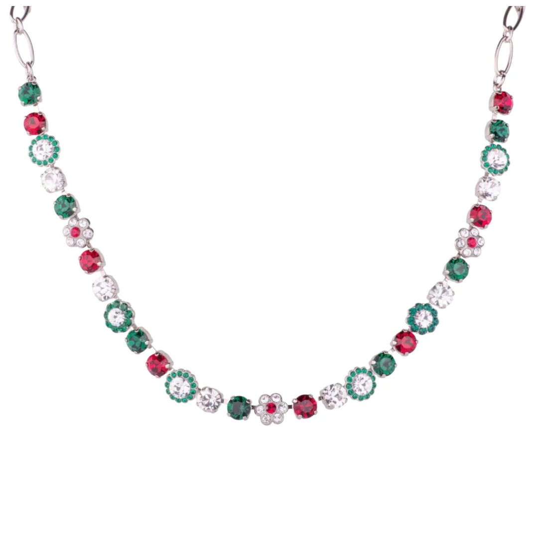 A silver-tone necklace featuring alternating round red and green gemstones with clear crystal-like centers, arranged in a curved line on a plain white background.